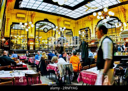 PARIS, Frankreich - große Menschenmenge, die Mahlzeiten im Budget-Brasserie-Restaurant „Bouillon Chartier“, 9. Bezirk, mit Kellner teilt. Stockfoto