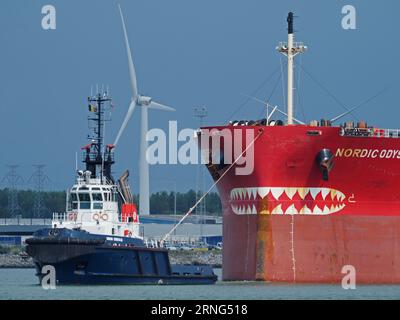 Öltankschiff Nordic Odyssey mit Schleppboot am Bug, Bug mit Haizähnen verziert. Vlissingen, Zeeland, Niederlande Stockfoto