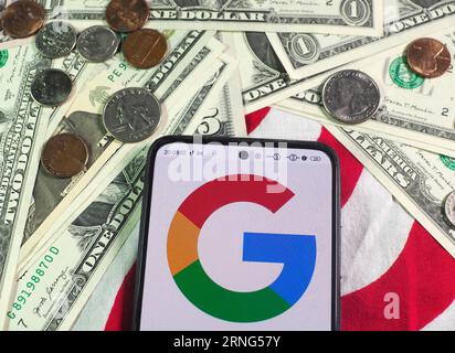 In dieser Abbildung wird das Google-Logo auf einem Smartphone und US-Banknoten und -Münzen im Hintergrund angezeigt. Stockfoto