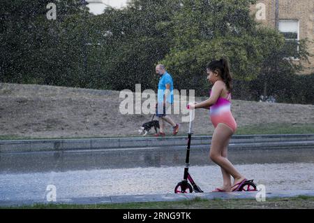 (160914) -- LONDON, 14. September 2016 -- Ein Mädchen, Das auf einem Roller fährt, kühlt sich am 14. September 2016 in einem Brunnen in London, England ab, da Londoner mehrere Tage heißes Wetter genießen, wobei Dienstag die höchste Septembertemperatur in Großbritannien seit 1911 aufzeichnete. ) GROSSBRITANNIEN-LONDON-HEAT HanxYan PUBLICATIONxNOTxINxCHN 160914 London Sept 14 2016 ein Mädchen, das einen Roller reitet, kühlt AM 14. September 2016 in einem Brunnen in London England ab, während Londoner mehrere Tage heißes Wetter genießen, wobei Dienstag die höchste Septembertemperatur in Großbritannien seit 1911 aufzeichnete. Großbritannien London Heat HanxYan PUBLICATIONxNOTx Stockfoto