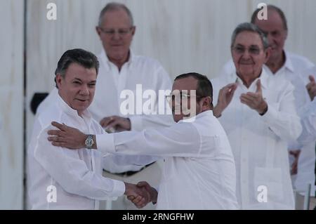 (160926) -- CARTAGENA, 26. September 2016 -- der kolumbianische Präsident Juan Manuel Santos (Front L) gibt dem Oberbefehlshaber der Revolutionären Streitkräfte Kolumbiens (FARC), Timoleon Jimenez (Front R), bei der Unterzeichnungszeremonie des endgültigen Friedensabkommens, das die kolumbianische Regierung und die FARC am 26. September 2016 in Cartagena, Kolumbien, geschlossen haben, die Hand. Der kolumbianische Präsident Juan Manuel Santos und der FARC-Oberbefehlshaber Timoleon Jimenez unterzeichneten am Montagnachmittag in Cartagena einen historischen Friedensvertrag, der einen 52-jährigen Konflikt beendete. (CE) KOLUMBIEN-CARTAGENA-FARC-FRIEDENSABKOMMEN JHONXPAZ Stockfoto