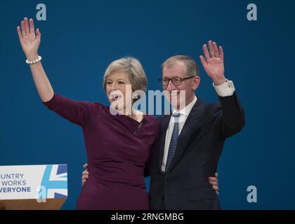 (161005) -- BIRMINGHAM, 5. Oktober 2016 -- die britische Premierministerin Theresa May (L) und ihr Ehemann Philip begrüßen das Publikum nach ihrer Rede am letzten Tag der Konservativen Parteikonferenz in Birmingham, Großbritannien, am 5. Oktober 2016. Die britische Premierministerin Theresa May schloss am Mittwoch die Jahreskonferenz der Konservativen in Birmingham und sagte, dass ihre Partei den Mittelpunkt der Politik einnehmen soll. GROSSBRITANNIEN-BIRMINGHAM-KONSERVATIVE PARTEIKONFERENZ-FAZIT HanxYan PUBLICATIONxNOTxINxCHN Birmingham OCT 5 2016 britische Premierministerin Theresa May l und ihr Ehemann Philip begrüßen das Publikum nach h Stockfoto