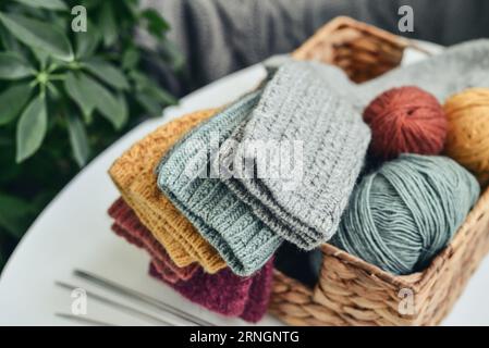 Handgestrickte Wollsocken in verschiedenen Farben in einem Korbgeflecht auf einem Couchtisch aus nächster Nähe Stockfoto
