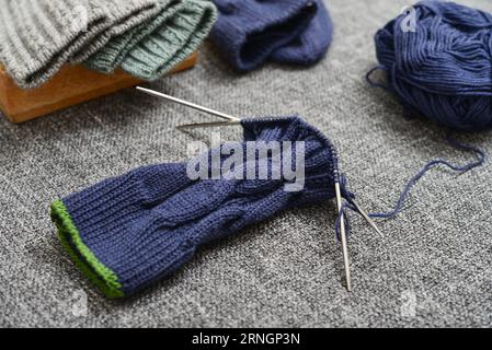 Handgestrickte blaue Wollsocke auf grauem Hintergrund Stockfoto