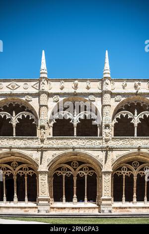 BELEM Portugal // BELEM, Portugal — kunstvolle zweistöckige Kreuzgänge säumen den Innenhof von Mosteiro dos Jeronimos, ein UNESCO-Weltkulturerbe und Meisterwerk der Manuelinarchitektur. Das Kloster, auch bekannt als Hieronymitenkloster, wurde im frühen 16. Jahrhundert von König Manuel I. beauftragt, Vasco da Gama's erfolgreiche Reise nach Indien zu gedenken. Der Bau begann um 1501 und wurde fast ein Jahrhundert lang fortgesetzt, wobei kunstvolle Steinschnitzereien und maritime Motive verwendet wurden, die für Portugals Zeitalter der Entdeckung charakteristisch sind. Die Kreuzgänge sind mit komplizierten Sc Stockfoto