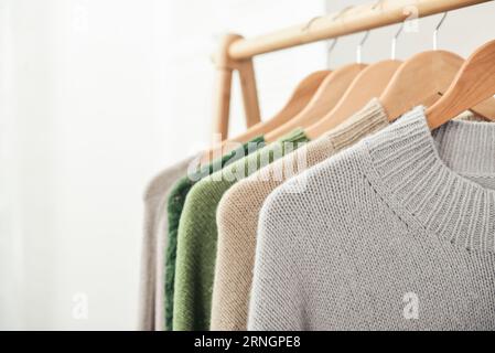 Bunte, handgestrickte Pullover auf Kleiderbügeln in Nahaufnahme. Modekonzept. Stockfoto