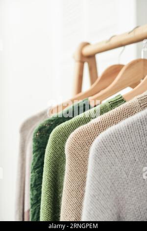 Bunte, handgestrickte Pullover auf Kleiderbügeln in Nahaufnahme. Modekonzept. Stockfoto