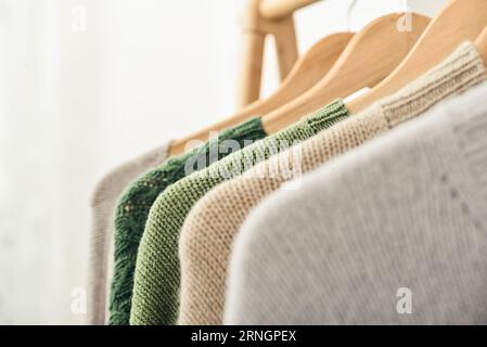 Bunte, handgestrickte Pullover auf Kleiderbügeln in Nahaufnahme. Modekonzept. Stockfoto