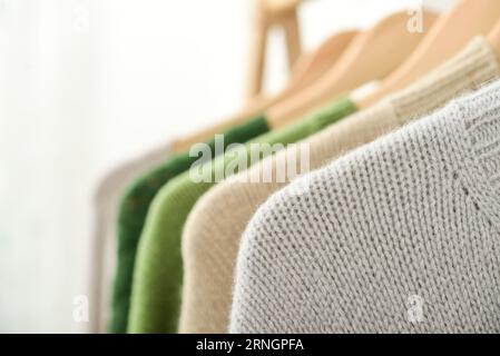 Bunte, handgestrickte Pullover auf Kleiderbügeln in Nahaufnahme. Modekonzept. Stockfoto