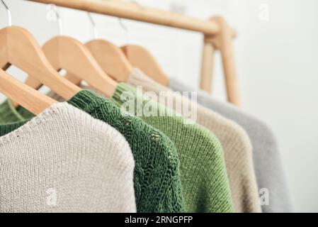 Bunte, handgestrickte Pullover auf Kleiderbügeln in Nahaufnahme. Modekonzept. Stockfoto