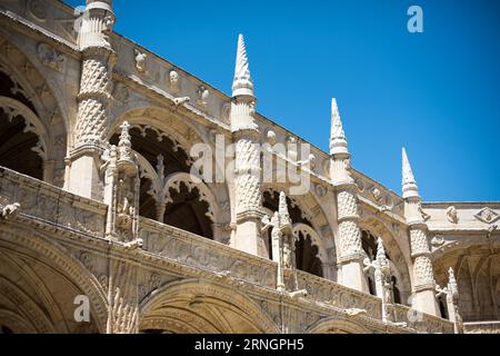 Klosterkloster von Jeronimos Belem Portugal // BELEM, Portugal — kunstvolle zweistöckige Kreuzgänge säumen den Innenhof von Mosteiro dos Jeronimos, ein UNESCO-Weltkulturerbe und Meisterwerk der Manuelinarchitektur. Das Kloster, auch bekannt als Hieronymitenkloster, wurde im frühen 16. Jahrhundert von König Manuel I. beauftragt, Vasco da Gama's erfolgreiche Reise nach Indien zu gedenken. Der Bau begann um 1501 und wurde fast ein Jahrhundert lang fortgesetzt, wobei kunstvolle Steinschnitzereien und maritime Motive verwendet wurden, die für Portugals Zeitalter der Entdeckung charakteristisch sind. Die Kreuzgänge sind mit komplizierten Formen versehen Stockfoto