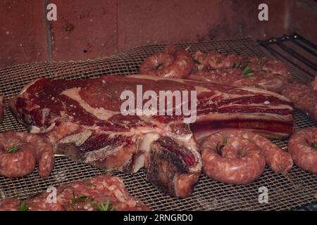 Gegrilltes Fleisch Medley: Eine köstliche Auswahl an Würstchen und gemischten Aufschnitten auf dem Grill Stockfoto