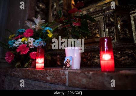 BELEM Portugal // BELEM, Portugal — Kerzen, Votive, Blumen und eine Karte des Heiligen Antonius ruhen auf einem Vorsprung an einem Altar in Mosteiro dos Jeronimos. Das Kloster, das zum UNESCO-Weltkulturerbe gehört, wurde im 16. Jahrhundert erbaut und stellt eines der bedeutendsten Beispiele der Manuelinarchitektur Portugals dar. Der Heilige Antonius von Padua, geboren in Lissabon, wird weithin als schutzheiliger der verlorenen Dinge verehrt und wird besonders in der portugiesischen katholischen Tradition geliebt. Das Kloster Jeronimos diente als spirituelles Zentrum für portugiesische Entdecker Stockfoto