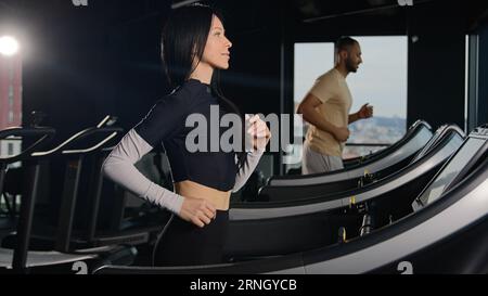 Sport Menschen Läufer Turnschuhe laufen auf Laufband in Sportgymnastik athletische Männer und Frauen laufen Workout fit Mädchen Athletin Sportlerin Training Cardio Stockfoto