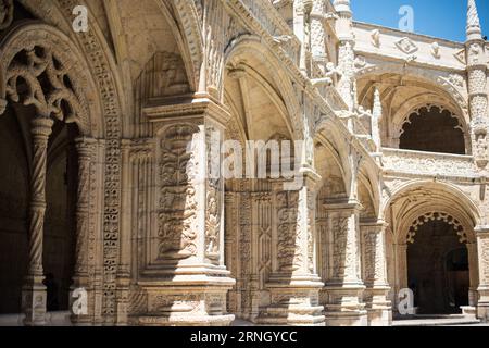 Mosteiro Dos Jeronimos Cloisters Manuelinarchitektur Lissabon Portugal / BELÉM, Lissabon, Portugal — kunstvolle zweistöckige Kreuzgänge des Klosters Jerónimos erstrecken sich um einen großen quadratischen Innenhof, deren Arkaden aus goldenem Kalkstein reich an geschnitzten maritimen Bildern sind, die für den Manuelinstil charakteristisch sind. Gegründet von König Manuel I. mit dem Bau von 1501 bis 1502 unter Diogo de Boitaca, wurde der Kreuzgang um 1517 von João de Castilho fortgesetzt, dessen platereske Sensibilität sich mit dem bekannten Manuelinvokabular der Seile, Armillarsphären und dem Kreuz des Ordens von CH verschmolz Stockfoto