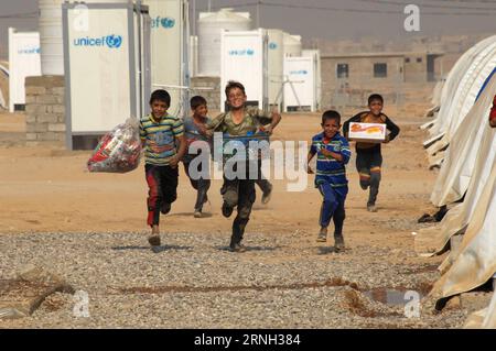 Bilder des Tages (161025) -- QAYYARAH, 25. Oktober 2016 -- Eine Gruppe von Jungen läuft am 25. Oktober 2016 im Jadah Camp in der Stadt Qayyarah im südlichen Mossul im Irak. Das UN-Büro für die Koordinierung humanitärer Angelegenheiten (OCHA), Stephane Dujarric, sagte am Dienstag gegenüber den Reportern, dass infolge der Militäroperation von Mossul im Irak fast 9.000 Menschen intern vertrieben werden. Lise Grande, die UN-Koordinatorin für humanitäre Hilfe im Irak, sagte, dass die militärischen Operationen zur Wiedereroberung Mossuls die größte humanitäre Krise im Jahr 2016 auslösen könnten, da die Sicherheitslage in der Region die Fähigkeit der Hilfsorganisationen einschränkt, Hel zu liefern Stockfoto