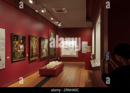 Kind, das ein Foto mit einem Mobiltelefon, Smartphone, in einem Raum des Provinzmuseums Palacio del Infantado in der Stadt Guadalajara, Spanien, macht. Stockfoto