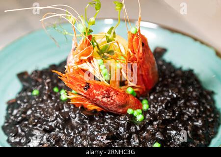 Schwarzes Risotto mit Garnelen in Valletta, Malta. Die Schale ist schwarz mit Tintenfischtinte. Stockfoto