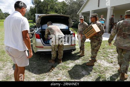 Cedar Key, Usa. August 2023 31. Soldaten der US-Armee mit der Florida National Guard, 53d Brigade Support Battalion, laden Nahrung und Wasser in ein Fahrzeug der Bewohner nach dem Hurrikan Idalia, 31. August 2023 in Cedar Key, Florida. Kredit: SSgt. Cassandra Vieira/US Army/Alamy Live News Stockfoto