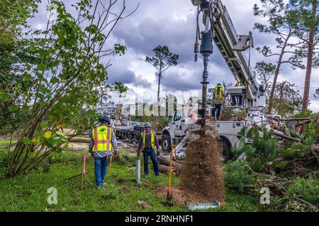 Perry, Usa. September 2023. Versorgungsarbeiter beginnen mit der Installation neuer Strommasten und Stromleitungen nach dem Hurrikan Idalia, 1. September 2023 in Perry, Florida. Die kleine Stadt von 7.000 wurde vom Hurrikan Idalia zerschreddert Bäume und zerstörte Häuser. Quelle: Steve Zumwalt/FEMA/Alamy Live News Stockfoto