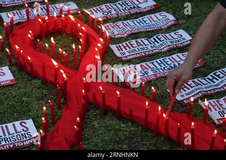 (161201) -- QUEZON CITY, 1. Dezember 2016 -- Ein Mann zündet Kerzen auf einem roten, bandförmigen Tuch an, anlässlich des Welt-AIDS-Tages in Quezon City, Philippinen, 1. Dezember 2016. Menschen auf der ganzen Welt beobachten den Welt-Aids-Tag, um das Bewusstsein für HIV/Aids zu schärfen und diese zu verhindern. ) (Sxk) PHILIPPINEN-QUEZON-WORLD AIDS DAY ROUELLExUMALI PUBLICATIONxNOTxINxCHN Stockfoto