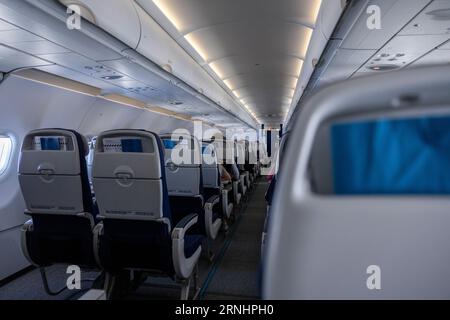 Innenraum einer Flugzeugkabine mit leeren Sitzen in einer Reihe. Stockfoto