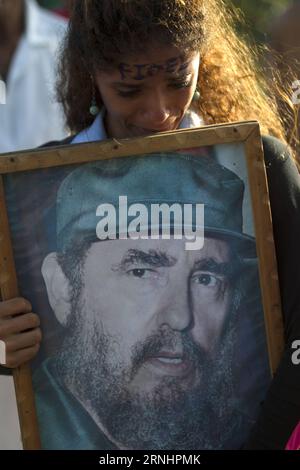 (161204) -- SANTIAGO DE CUBA, 4. Dezember 2016 -- Eine Frau hält ein Poster des kubanischen Revolutionsführers Fidel Castro während der Passage seines Begräbniskorteges auf dem Friedhof Santa Ifigenia in der Stadt Santiago de Cuba, Kuba, am 4. Dezember 2016. Die Überreste des kubanischen Revolutionsführers und ehemaligen Präsidenten Fidel Castro wurden am Sonntagmorgen auf dem Friedhof Santa Ifigenia in Santiago de Cuba begraben. David de la Paz) (mA) (ce) CUBA-SANTIAGO DE CUBA-FIDEL CASTRO e DavidxdexlaxPaz PUBLICATIONxNOTxINxCHN Santiago de Cuba DEC 4 2016 eine Frau hält ein Poster des kubanischen Revolutionsführers Fidel Castro d Stockfoto