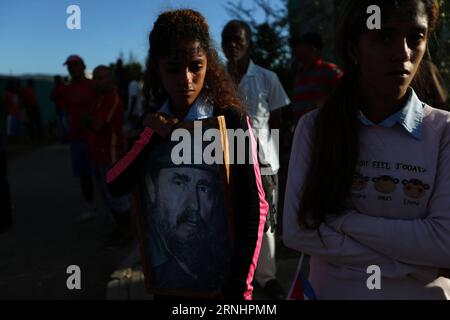 (161204) -- SANTIAGO DE CUBA, 4. Dezember 2016 -- Eine Frau hält ein Poster des kubanischen Revolutionsführers Fidel Castro während der Passage seines Begräbniskorteges auf dem Friedhof Santa Ifigenia in der Stadt Santiago de Cuba, Kuba, am 4. Dezember 2016. Die Überreste des kubanischen Revolutionsführers und ehemaligen Präsidenten Fidel Castro wurden am Sonntagmorgen auf dem Friedhof Santa Ifigenia in Santiago de Cuba begraben. David de la Paz) (mA) (ce) CUBA-SANTIAGO DE CUBA-FIDEL CASTRO e DavidxdexlaxPaz PUBLICATIONxNOTxINxCHN Santiago de Cuba DEC 4 2016 eine Frau hält ein Poster des kubanischen Revolutionsführers Fidel Castro d Stockfoto