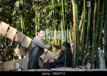 (161208) -- CHONGQING, 7. Dezember 2016 -- Li Gaoqiang (L) und sein Vater Li Shilin trockneten Tuhuo Papier in der Stadt Xinglong, südwestchinesisches Chongqing, 7. Dezember 2016. Die Familie Li, die in der Stadt Xinglong in Chongqing lebt, hat das traditionelle Handwerk der Tuhuo-Papierherstellung über fünf Generationen weitergegeben. Tuhuo-Papier aus Bambus, das in lokalen Gebieten angebaut wird, erfordert einen hohen Standard an Techniken in allen Verarbeitungsstufen. Aufgrund der hohen Arbeitsintensität, der geringen Verkaufszahlen und der geringen Rendite wird das Handwerk jedoch nur von wenigen jungen Menschen vererbt, was die Regierung dazu veranlasst hat, es als Tourismusprojekt zu entwickeln Stockfoto