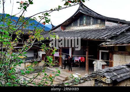 (161216) -- FUZHOU, 15. Dezember 2016 -- Eine Frau trocknet Kleidung im Hof des Zhongpu Stockaded Village in der Changqing Township im Yongtai County, südöstliche Provinz Fujian, 15. Dezember 2016. Das Dorf Zhongpu Stockaded wurde während des Jiaqing-Kaiserregimes der Qing-Dynastie (1760-1820) erbaut und ist ein Hofgebäude aus Erde und Holz, das eine Fläche von 10.000 Quadratmetern mit insgesamt 182 Zimmern umfasst. Das stockbesetzte Dorf ist seit über 200 Jahren erhalten und an die 10. Generation der Bewohner übergegangen. ) (Yxb) CHINA-FUJIAN-STOCKADED VILLAGE(CN) ZhangxGuojun PUBLICATIONxNOTxINxCHN Stockfoto