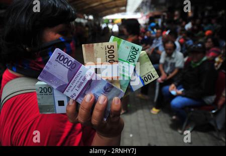 (161219) -- JAKARTA, 19. Dezember 2016 -- eine indonesische Frau hält neue Banknoten, die bei einer mobilen Bank in Jakarta, Indonesien, am 19. Dezember 2016 umgetauscht werden. Die Bank Indonesia veröffentlichte am Montag sieben neue Banknoten und vier neue Münzen mit den Bildern von zwölf nationalen Helden. (Sxk) INDONESIEN-JAKARTA-NEUE BANKNOTEN Zulkarnain PUBLICATIONxNOTxINxCHN Jakarta DEZ 19 2016 an indonesische Frau hält neue Banknoten, die BEI einer Mobile Bank in Jakarta Indonesien DEZ 19 2016 Bank Indonesia AM Montag veröffentlicht sieben neue Banknoten und vier neue Münzen mit den Bildern von 12 National Heroes sxk Indonesia Jakarta New BA Stockfoto