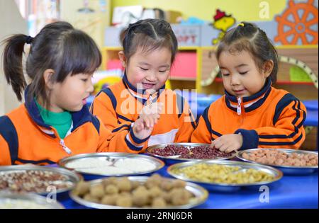 (170104) -- SHIJIAZHUANG, 4. Januar 2017 -- Kinder betrachten die Inhaltsstoffe von LABA Congee in einem Kindergarten in Xingtai, nordchinesische Provinz Hebei, 4. Januar 2017. Das LABA Festival, ein traditioneller chinesischer Feiertag am achten Tag des 12. Mondmonats, wird dieses Jahr am 5. Januar stattfinden. An diesem Tag ist es üblich, ein besonderes LABA-Congee oder acht Schatzbrei zu essen, die normalerweise aus mindestens acht Zutaten hergestellt werden und die Gebete der Menschen für Ernte, Glück und Frieden darstellen. ) (wyo) CHINA-HEBEI-LABA CONGEE (CN) ZhuxXudong PUBLICATIONxNOTxINxCHN Shijiazhuang Jan 4 2017 Kinder Blick auf den Ingred Stockfoto