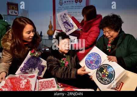 (170117) -- PEKING, 17. Januar 2017 -- der chinesische Papierschneidemeister Zhou Huiyan (2. L) präsentiert ihre Werke auf einer Tempelmesse in Peking, der Hauptstadt Chinas, am 17. Januar 2017. Während der nächsten sechs Tage präsentieren traditionelle Volkskünstler ihre Werke und Techniken des immateriellen Kulturerbes auf der Tempelmesse. Li Xin) (wjl) CHINA-BEIJING-TEMPLE FAIR FOLK ART SHOW Lixin PUBLICATIONxNOTxINxCHN Beijing Jan 17 2017 Chinese Paper Cutting Master Zhou 2nd l präsentiert ihre Werke AUF einer Temple Fair in Peking Hauptstadt von China AM 17. Januar 2017 während der nächsten sechs Tage werden traditionelle Folk-Künstler die These präsentieren Stockfoto