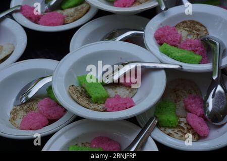 Dawet serabi für Käufer auf einem traditionellen Markt. Es ist traditionelles javanisches Essen aus Reismehlsträngen, die zu einem Ball zusammengerollt werden; gegessen mit Kokosmilch A Stockfoto