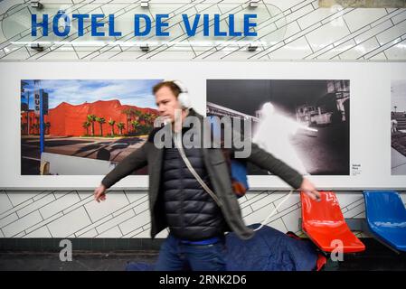 (170228) -- PARIS, 28. Februar 2017 -- Ein Passagier imitiert die Figur auf einem Magnum-Foto, das hinter ihm im Hotel de Ville Station der Pariser Metro-Linie 1 in Paris, Frankreich, am 28. Februar 2017 gezeigt wurde. Anlässlich des 70-jährigen Bestehens von Magnum Photos stellt die RATP (Autonomous Operator of Parisian Transports) von Februar 28 bis Juni 30 insgesamt 174 Magnum Photos in ihren 11 Stationen in Paris aus. )(zf) FRANCE-PARIS-RATP-MAGNUM FOTOS ChenxYichen PUBLICATIONxNOTxINxCHN Paris Feb 28 2017 ein Passagier imitiert die Figur in einem Magnum Foto, das hinter IHM im Hotel de Ville Station der Pariser Metro gezeigt wird Stockfoto