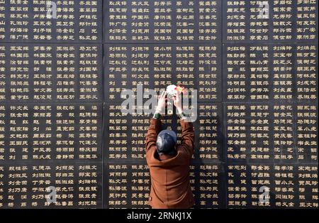 (170403) -- TANGSHAN , 3. April 2017 -- Ein Bürger paßt Papierblumen neben dem Namen des Verwandten, der beim Erdbeben von Tangshan 1976 getötet wurde, vor einer Gedenkmauer in Tangshan, nordchinesische Provinz Hebei, 3. April 2017. Anfang April fällt der Tag der Grabdurchsuchung, oder Qingming, wenn die Chinesen ihre verstorbenen Lieben durch den Besuch von Gräbern gedenken. ) (Zyd) CHINA-HEBEI-TANGSHAN-EARTHQUAKE-QINGMING HOLIDAY (CN) MuxYu PUBLICATIONxNOTxINxCHN Tang Shan 3. April 2017 ein Bürger paßt Papierblumen neben dem Namen des VERWANDTEN, der beim Tang Shan-Erdbeben 1976 vor einem Wa-Denkmal GETÖTET WURDE Stockfoto