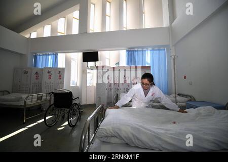 (170410) -- CHANGSHA, 10. April 2017 -- Oberschwester Liu Li macht das Bett in der Abteilung des Angdong Krankenhauses im Dorf Angdong im Kreis Baojing, Provinz Hunan in Zentralchina, 1. April 2017. Dieses 2014 eröffnete neue ländliche Krankenhausgebäude war für seine einzigartige Bauweise bekannt. Er wurde 2016 vom Royal Institute of British Architects (RIBA) mit dem International Emerging Architect Prize ausgezeichnet. (Ry) CHINA-HUNAN-RURAL HOSPITAL (CN) LixGa PUBLICATIONxNOTxINxCHN Changsha 10. April 2017 Oberschwester Liu Left macht das Bett in der Abteilung des Krankenhauses Stockfoto