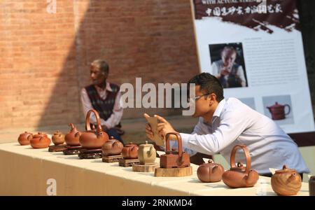 (170411) -- LALITPUR, 11. April 2017 -- Ein Besucher macht Fotos für die ausgestellten Tontöpfe während der Ausstellung Lotus Teapot: The Art of Yixing Redware Exhibition, die die Töpfe aus einzigartigem Zisha-Ton auf dem Patan Durbar Square in Lalitpur, Nepal, 10. April 2017 zeigt. Yixing ist bekannt als die Heimat von chinesischem Redware aus dem einzigartigen Zisha-Ton, auch bekannt als edler Ton, einer einzigartigen Minenart, die nirgendwo sonst auf der Welt zu finden ist. )(gj) NEPAL-LALITPUR-EXHIBITION-YIXING REDWARE SunilxSharma PUBLICATIONxNOTxINxCHN 170411 Lalitpur 11. April 2017 ein Besucher macht Fotos für die ausgestellten Stockfoto