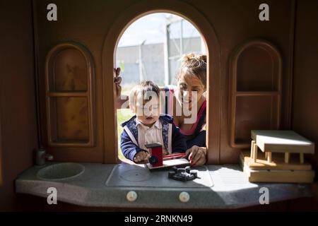 (170413) -- FLORENCIO VARELA, 13. April 2017 -- Nancy Oliver Ledezma (R) und ihr einjähriger Sohn Timoteo (L) spielen im Hof des Hauses, das sie mit drei weiblichen Häftlingen und ihren Kindern in der Kriminaleinheit 54 teilen, als Teil des Pilotprogramms Häuser für Frauen mit Kindern in Florencio Varela, Argentinien, am 12. April 2017. Das vom Justizministerium in der Provinz Buenos Aires initiierte Pilotprogramm zielt darauf ab, die Lebensqualität der weiblichen Häftlinge, die mit ihren Kindern leben, zu verbessern. Das Programm bietet kleine Häuser innerhalb eines Gefängniskomplexes an, damit die Kinder die Auswirkungen vermeiden können Stockfoto