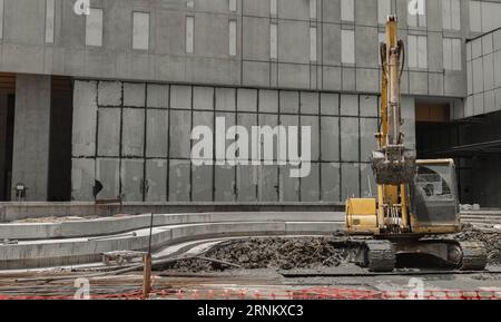 Bangkok, Thailand - 31. August 2023 - Ein Baubagger von gelber Farbe steht vor der Baustelle. Grader und Bagger Stockfoto