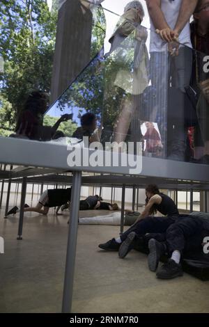 (170515) -- VENEDIG, 15. Mai 2017 -- Künstler treten im Pavillon Deutschlands während der 57. Art Biennale in Venedig, Italien, am 13. Mai 2017 auf. Die deutsche Choreografin Anne Imhof wurde mit dem Goldenen Löwen für die beste nationale Teilnahme an der 57. Art Biennale in Venedig ausgezeichnet. Für ihr Stück Faust nach der klassischen deutschen Geschichte eines Mannes, der seine Seele gegen unbegrenztes Wissen und Macht an den Teufel verkauft, füllte Imhof den weißen, rechteckigen Pavillon Deutschlands mit sich kreuzenden Glaswänden und -Böden. und dann eine Gruppe von Künstlern im Keller platziert. Besucher beobachten die Künstler Stockfoto