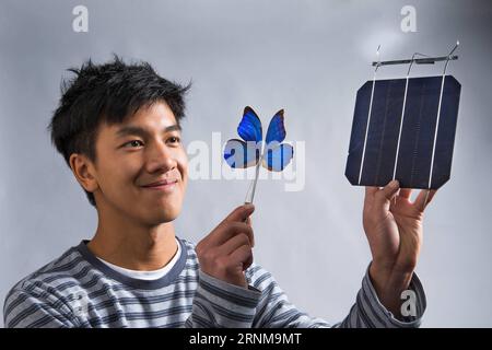 (170518) -- CANBERRA, 18. Mai 2017 -- Foto der Australian National University () zeigt den Co-Forscher Kevin Le mit einem blauen Morpho-Schmetterling und einer Solarzelle in Canberra, Australien, 16. Mai 2017. Schmetterlingsflügel könnten dazu verwendet werden, neue Technologien in Solarzellen zu inspirieren, so Forscher, und fügen hinzu, dass das Filtern von Licht ein Hauptmerkmal zukünftiger Solarprojekte sein könnte. ) (zw) AUSTRALIA-CANBERRA--BUTTERFLY WINGS-TECHNOLOGY ANU PUBLICATIONxNOTxINxCHN Canberra 18. Mai 2017 Foto der Australian National University zeigt Co-Forscher Kevin Le Holding a Blue Morpho Butterfly and a so Stockfoto