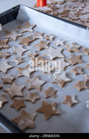 Hände eines kleinen 6-jährigen Kindes mit Keksen in Sternform. Kochkonzept Stockfoto