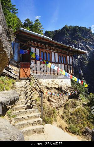 Blick von außen auf die traditionelle Bhutan-Struktur aus Holz und Stein entlang des zerklüfteten Bergpfads zum Tiger's Nest Kloster in der Nähe von Paro, Bhutan Stockfoto