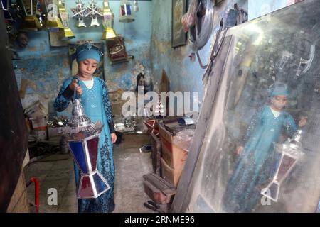 (170524) - KAIRO, 24. Mai 2017 -- Hussein Sayyids Tochter zeigt am 20. Mai 2017 in ihrer Vater-Werkstatt in Kairo, Ägypten, eine traditionelle handgefertigte Laterne. Sayyids Werkstatt befindet sich in einem alten Gebäude in einer Straße voller Werkstätten in Al-Qalaa, was die Zitadelle auf Arabisch bedeutet und sich auf Kairos Saladin-Zitadelle bezieht. Sayyids Werkstatt produziert bunte handgefertigte Glas- und Metalllaternen verschiedener Größen, die auf Arabisch als Fanoos bekannt sind und an Ständen vor der Werkstatt ausgestellt sind. Traditionelle handgefertigte Laternen dienen in Ägypten normalerweise während des jährlichen Ramadan-Monats als Dekoration. ) ÄGYPTEN-KAIRO-RAMADAN-HANDMADE L Stockfoto