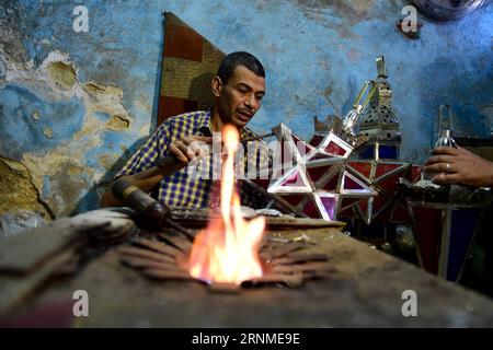 (170524) -- KAIRO, 24. Mai 2017 -- Hussein Sayyid stellt in seiner Werkstatt in Kairo, Ägypten, am 20. Mai 2017 eine traditionelle handgefertigte Laterne her. Sayyids Werkstatt befindet sich in einem alten Gebäude in einer Straße voller Werkstätten in Al-Qalaa, was die Zitadelle auf Arabisch bedeutet und sich auf Kairos Saladin-Zitadelle bezieht. Sayyids Werkstatt produziert bunte handgefertigte Glas- und Metalllaternen verschiedener Größen, die auf Arabisch als Fanoos bekannt sind und an Ständen vor der Werkstatt ausgestellt sind. Traditionelle handgefertigte Laternen dienen in Ägypten normalerweise während des jährlichen Ramadan-Monats als Dekoration. ) ÄGYPTEN-KAIRO-RAMADAN-HANDGEFERTIGTE LATERNEN ZHAOXDINGZHE Stockfoto