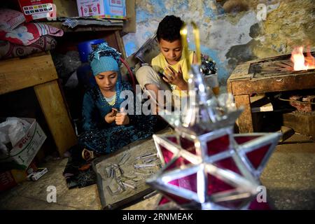(170524) - KAIRO, 24. Mai 2017 -- Hussein Sayyids Kinder stellen am 20. Mai 2017 in der Werkstatt ihres Vaters in Kairo, Ägypten, traditionelle handgefertigte Laternen her. Sayyids Werkstatt befindet sich in einem alten Gebäude in einer Straße voller Werkstätten in Al-Qalaa, was die Zitadelle auf Arabisch bedeutet und sich auf Kairos Saladin-Zitadelle bezieht. Sayyids Werkstatt produziert bunte handgefertigte Glas- und Metalllaternen verschiedener Größen, die auf Arabisch als Fanoos bekannt sind und an Ständen vor der Werkstatt ausgestellt sind. Traditionelle handgefertigte Laternen dienen in Ägypten normalerweise während des jährlichen Ramadan-Monats als Dekoration. ) ÄGYPTEN-KAIRO-RAMADAN-HANDGEMACHTE LA Stockfoto