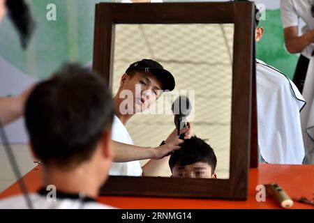 (170527) -- LINFEN, 27. Mai 2017 -- Ein Freiwilliger schneidet Haare für einen Schüler an der Red Ribbon School in Linfen, nordchinesische Provinz Shanxi, 25. Mai 2017. Die Schule Red Ribbon, das HIV/AIDS-Symbol, wurde 2011 gegründet. Es ist früher ein Klassenzimmer des Volkskrankenhauses Linfen Nr. 3. Insgesamt leben 36 HIV-Trägerschüler in drei Klassen in der Schule. Kinder konnten medizinische Behandlung, psychologische Ausbildung sowie akademische Ausbildung an der Schule erhalten. Sechzehn Senioren der Schule nahmen am Freitag an der Abschlussfeier Teil und nehmen an der diesjährigen Natio Teil Stockfoto