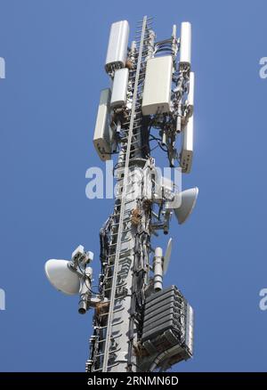 Zellenmast mit Antennen und Repeater für Telekommunikation Stockfoto