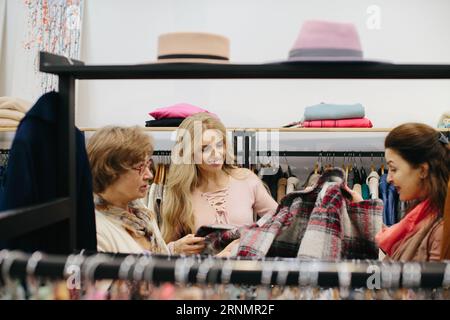 Ältere Frau, die sich in einem Laden Kleidung aussucht. Stockfoto